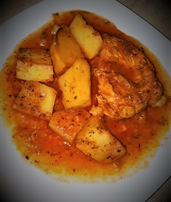 A plate with chicken and potatoes on it.