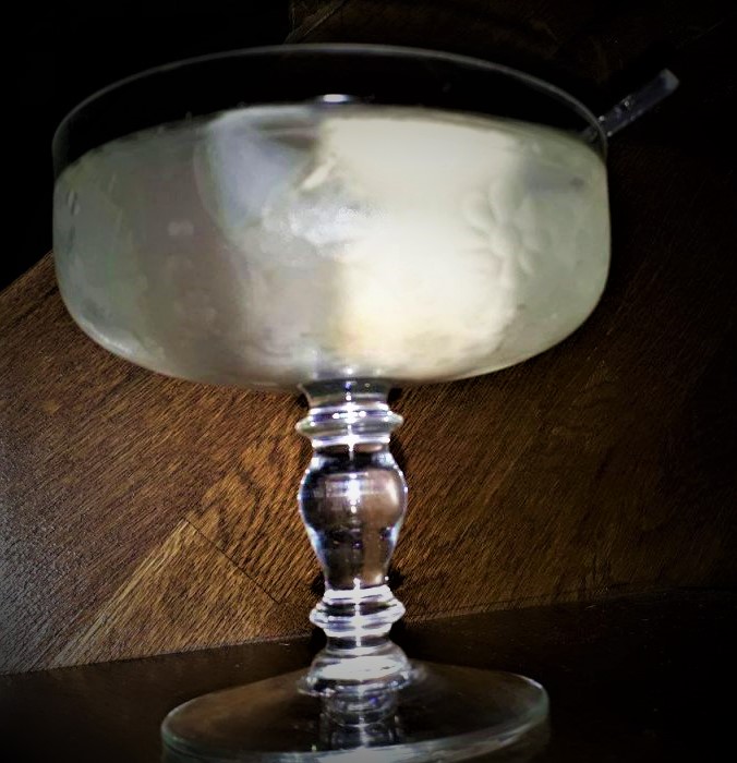 A Lychee Martini on a wooden table.