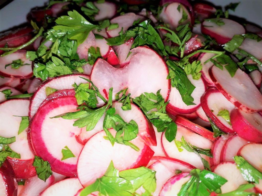Sliced red radishes on a plate.