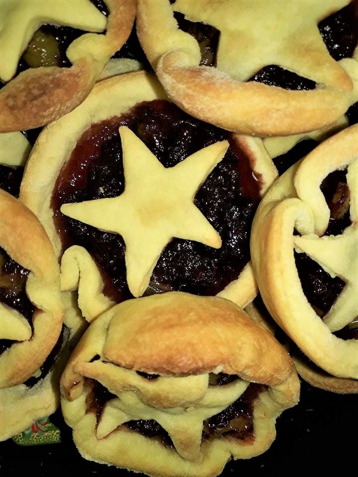 Star shaped christmas pies on a black plate.
