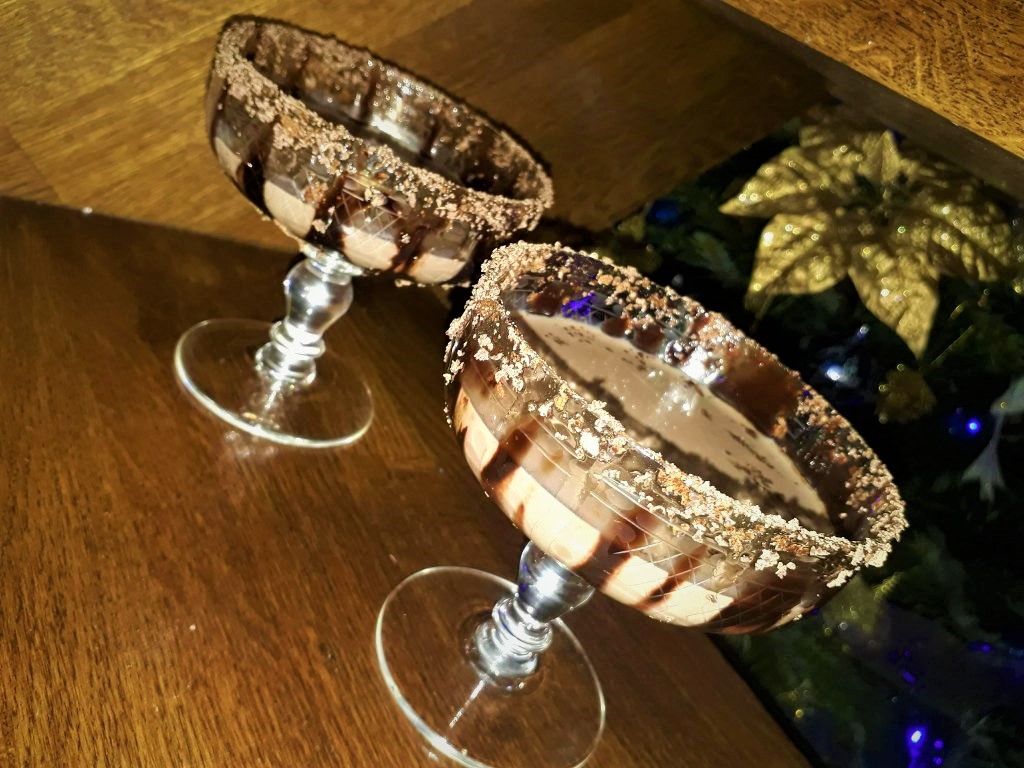 Two glasses of Baileys Chocolate Martinis on a wooden table.