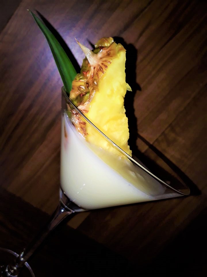 A martini with a pineapple on top.