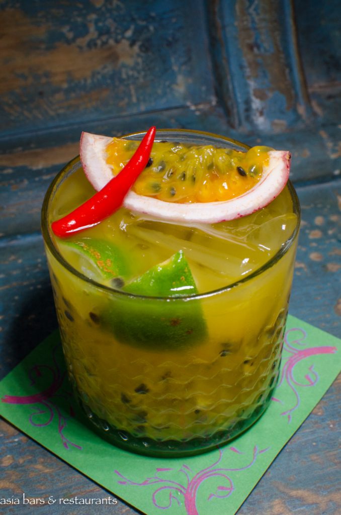 A drink with a slice of kiwi in it.
